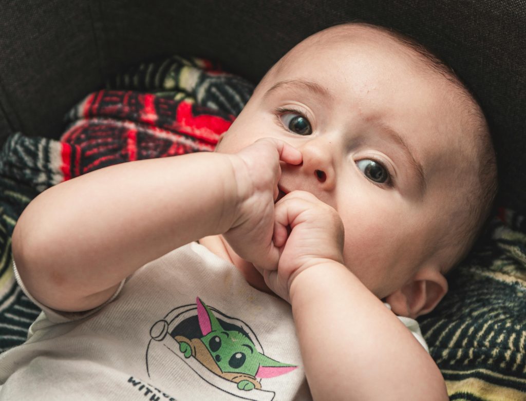 baby chewing on hands