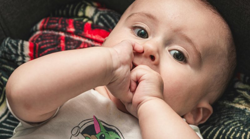 baby chewing on hands
